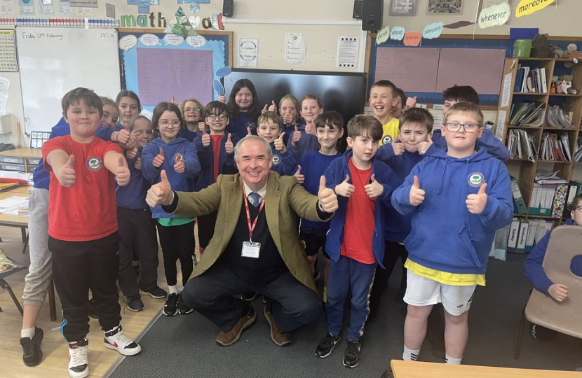 Sir Geoffrey smiling with children from Shebbear Primary School