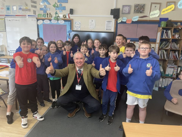 Sir Geoffrey smiling with children from Shebbear Primary School