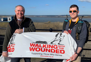 Geoffrey and Mr Ryan hold up a banner which reads: "WALKING WITH THE WOUNDED; Supporting Those Who Served."